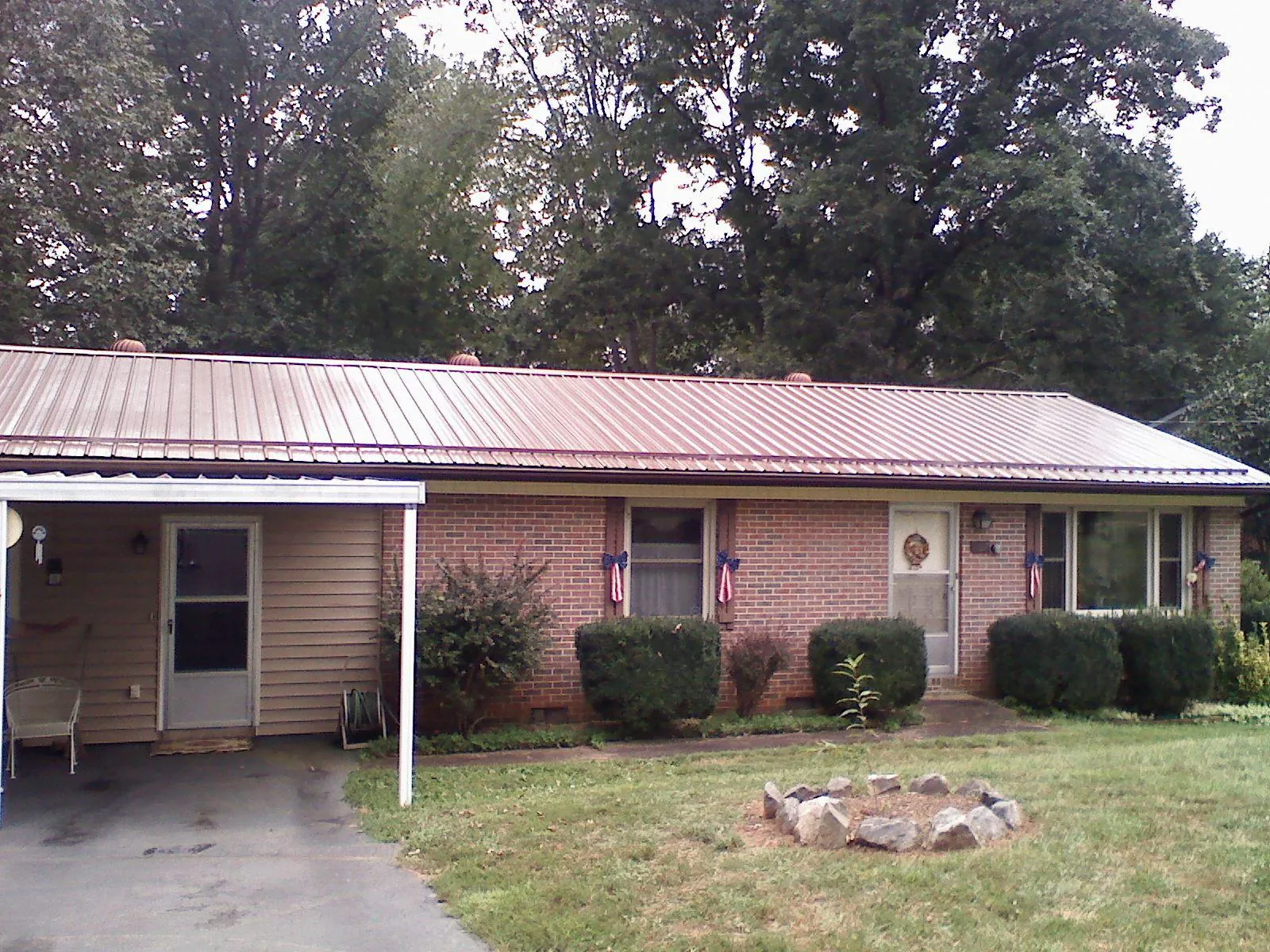 Bronze metal roof and carport on a brick ranch home — Roof Repair work by our crew in Hanska